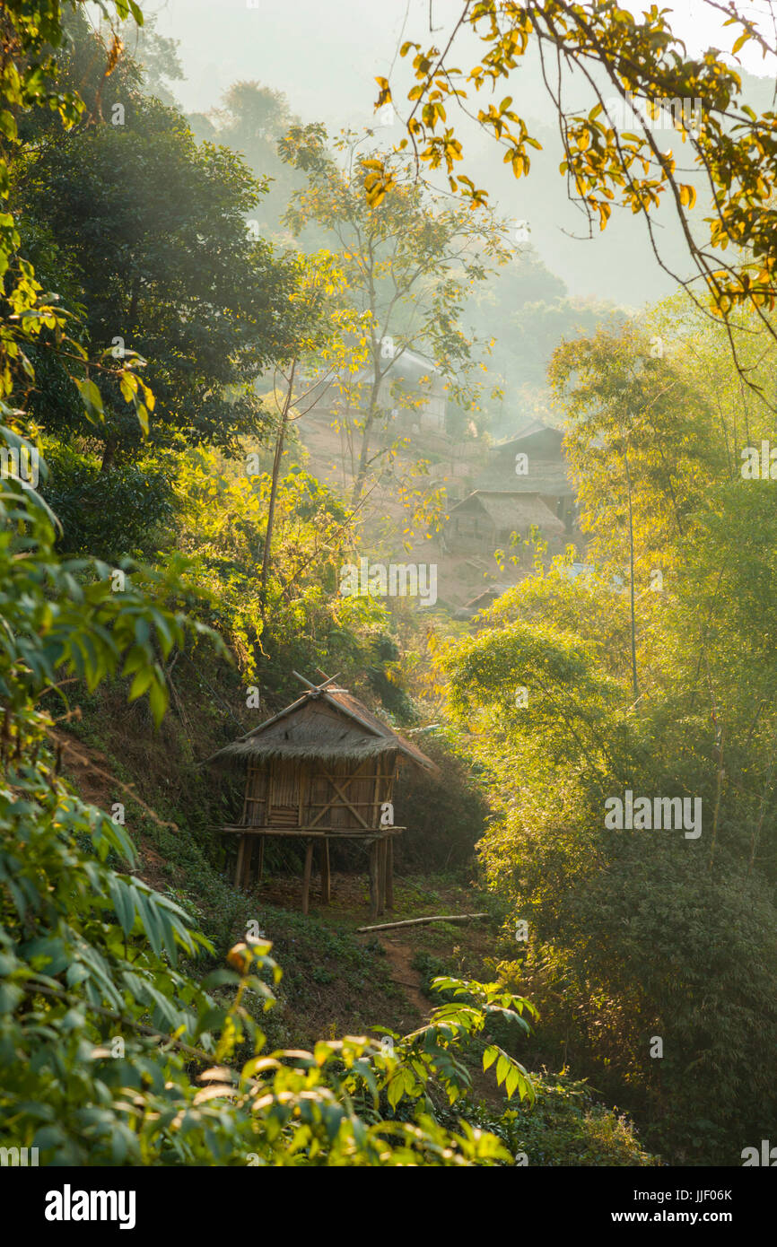 Sonnenuntergang über traditionellen strohgedeckten Hütten, Bäume und Bambus in Ban Sop Khip, Laos, ein Dorf, das völlig von Nam Ou River Dam #5 überschwemmt wird. Stockfoto