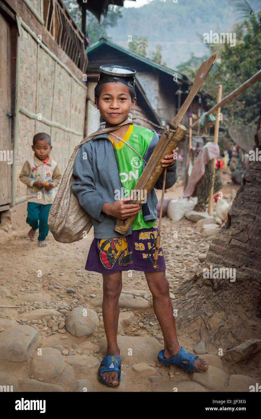 Ein Junge posiert stolz mit seiner Tauchmaske, Harpune und hausgemachte Saiteninstrument in Ban Huay Phouk, Laos. Stockfoto