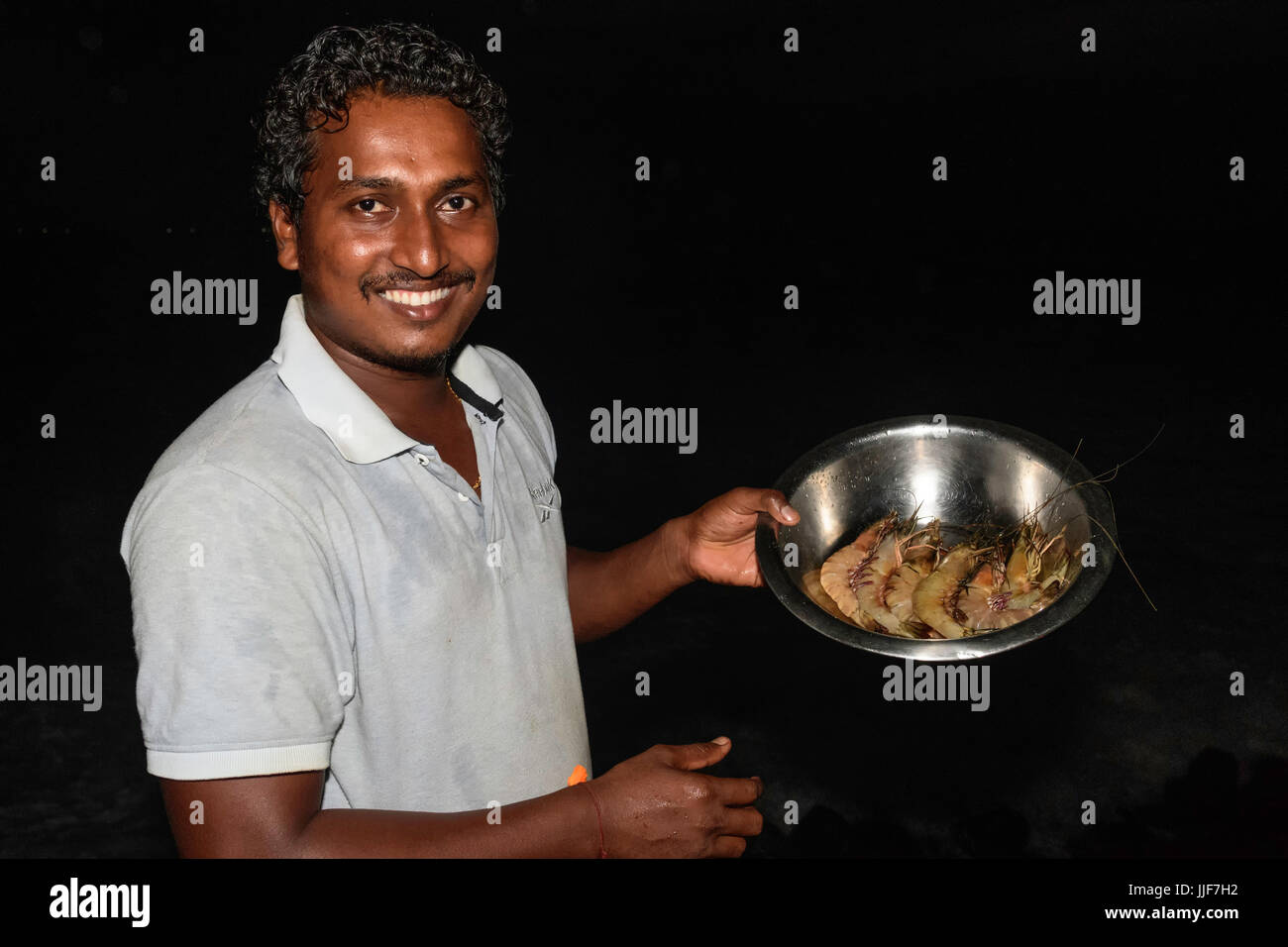 Kellner zeigt stolz Schüssel mit großen Garnelen in einem Restaurant Kerala Indien Stockfoto