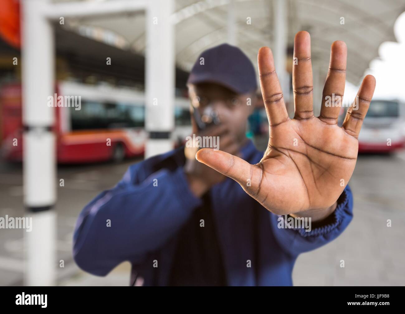 Digital Composite Wachmann sagen halt mit der Hand in der Busbahnhof Stockfoto