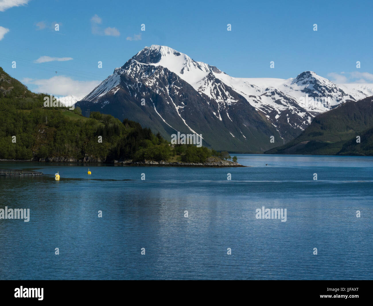 Ansicht des norwegischen Festlandes von einem Kreuzfahrtschiff Kreuzfahrt entlang ruhigen Fjord Norwegen Nordland mit späten Frühlingsschnee bedeckt Berge Stockfoto