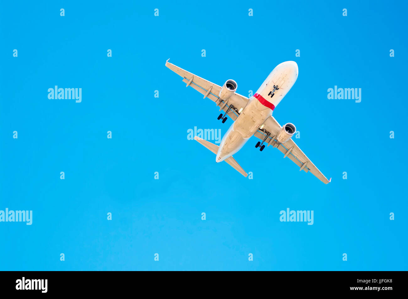 Kreuz-bearbeitetes Bild des Flugzeugs von unten gegen klar blauen Himmel an sonnigen Tag Stockfoto