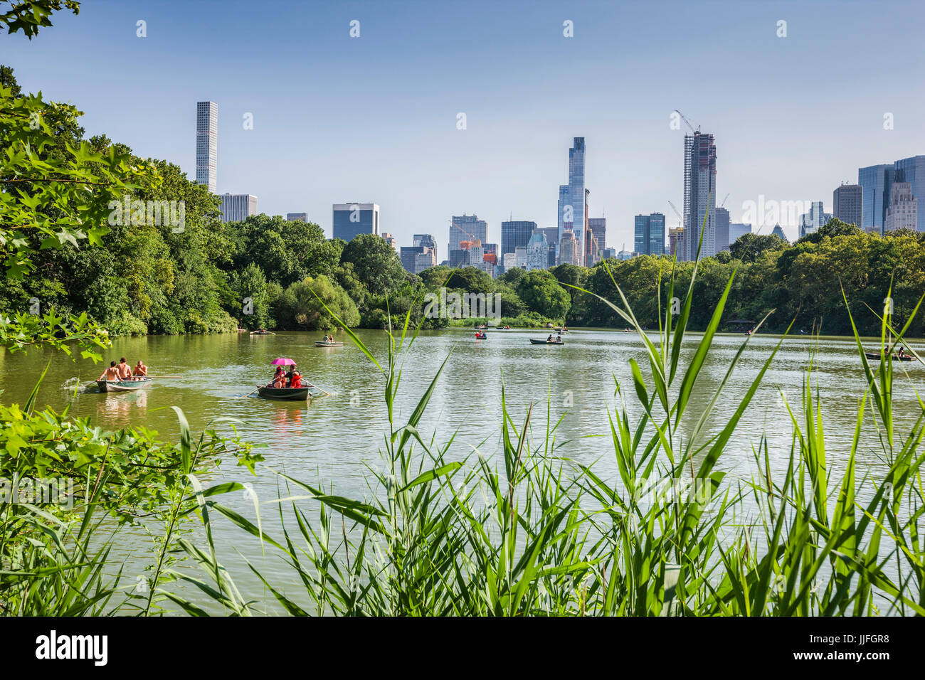 New York Central Park, Boot Rudern an einem sonnigen Tag mit Manhattan Gebäude auf der Rückseite Stockfoto