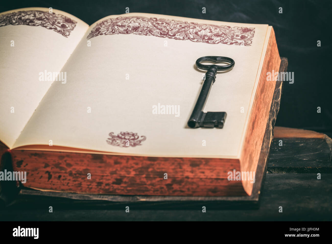 Schlüssel zum Wissen-Konzept. Schlüssel an einem Oldtimer Buch auf hölzernen Hintergrund Stockfoto