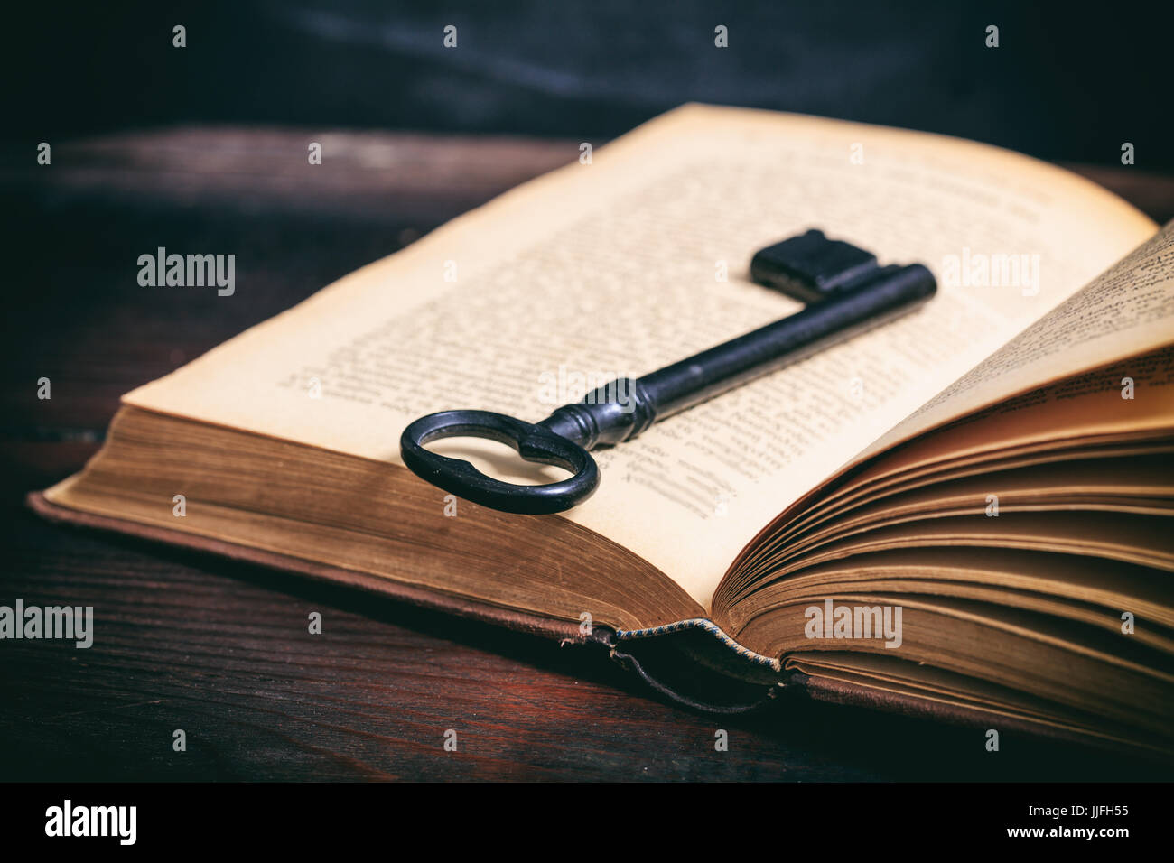 Schlüssel zum Wissen-Konzept. Schlüssel an einem Oldtimer Buch auf hölzernen Hintergrund Stockfoto