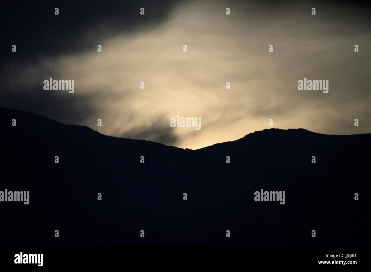 Sonnenaufgang über einen Berg durch Wolken kommen. Stockfoto