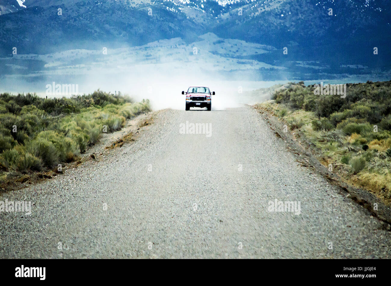 Ein Ford Pickup fahren über eine Schotterstraße mit wehenden Staub hinter sich. Stockfoto