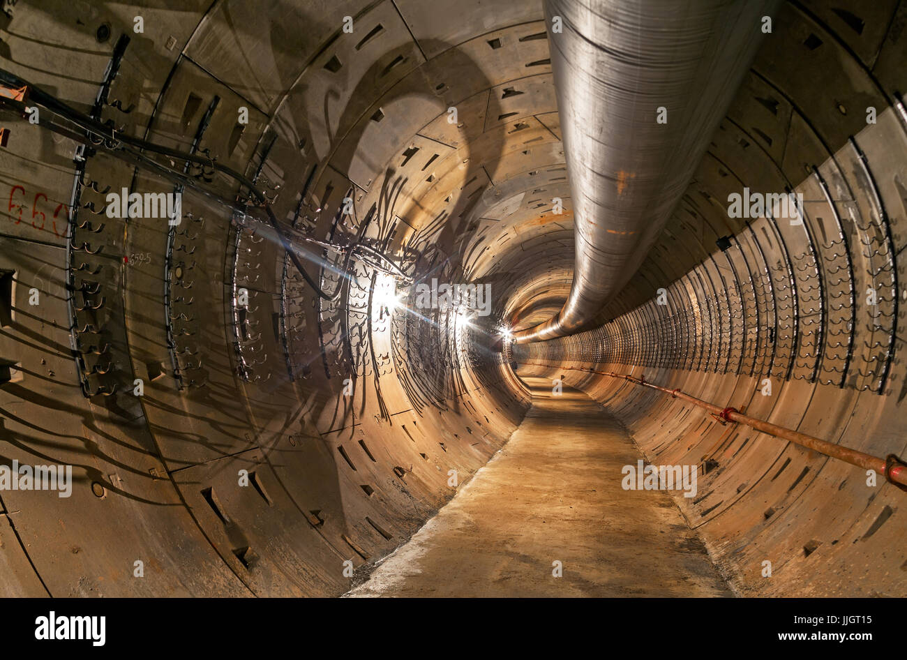 Leere u-Bahn-Tunnel im Bau. Große temporäre Entlüftungsrohr unter der Decke. Stockfoto