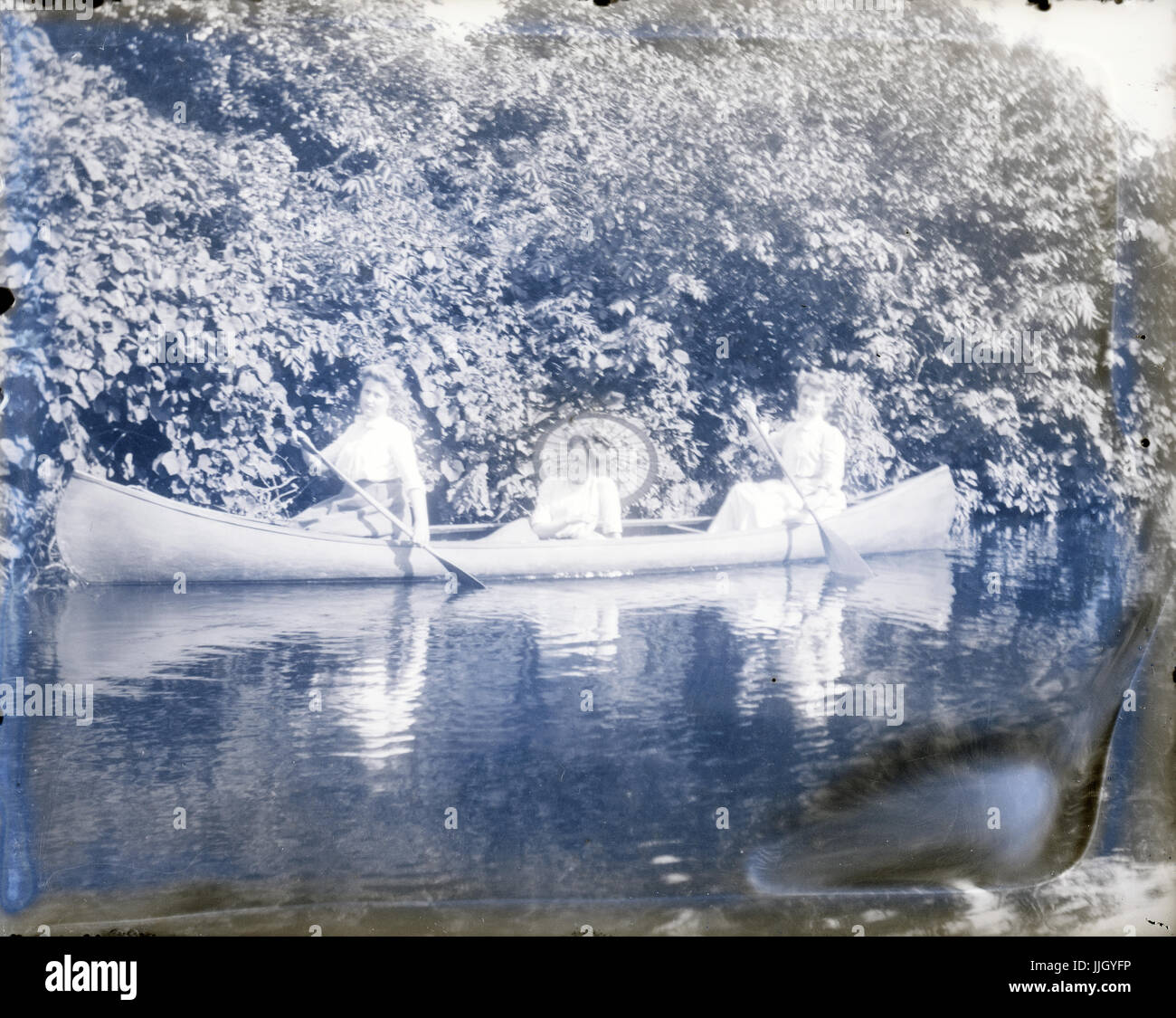 Antike c1910 Foto, drei Frauen in einem Kanu. Lage ist möglicherweise Central Park in New York City, New York oder Roger Williams Park in Providence, Rhode Island, USA. QUELLE: ORIGINALFOTO. Stockfoto