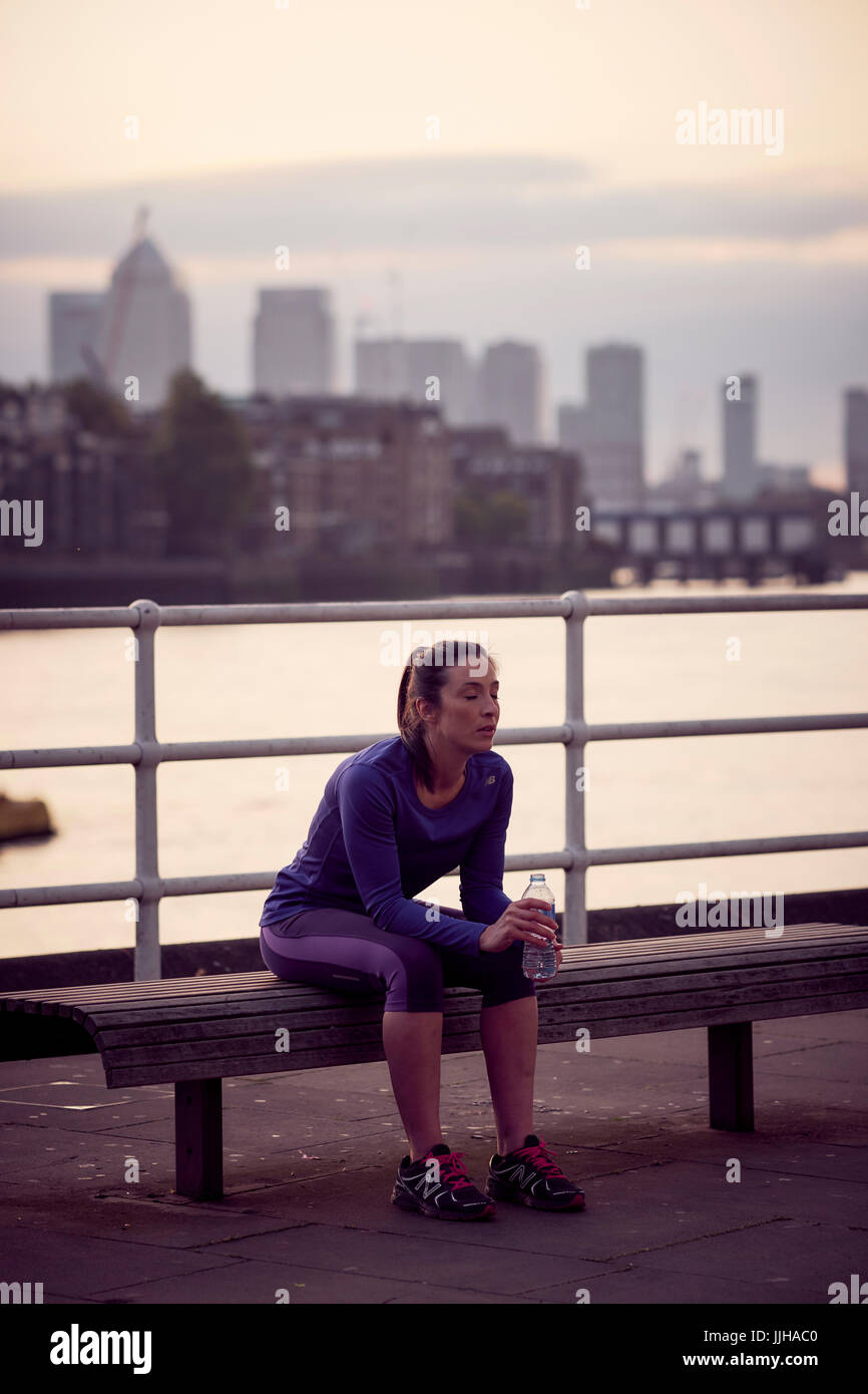 Eine Frau, ruhen Sie sich nach einem Lauf der Themse in London. Stockfoto