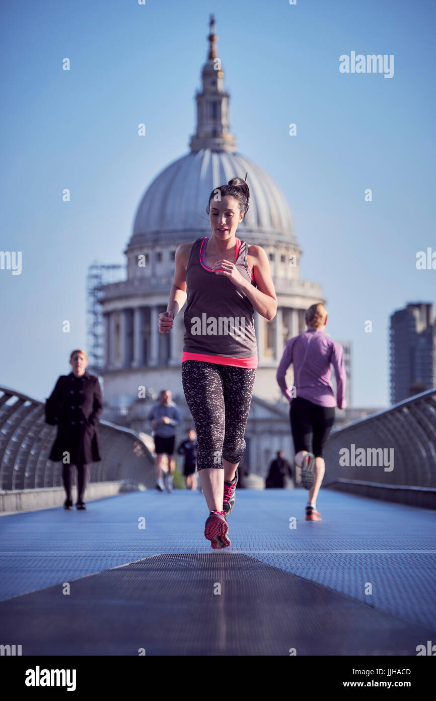 Eine Frau läuft über die Millennium Bridge in London. Stockfoto