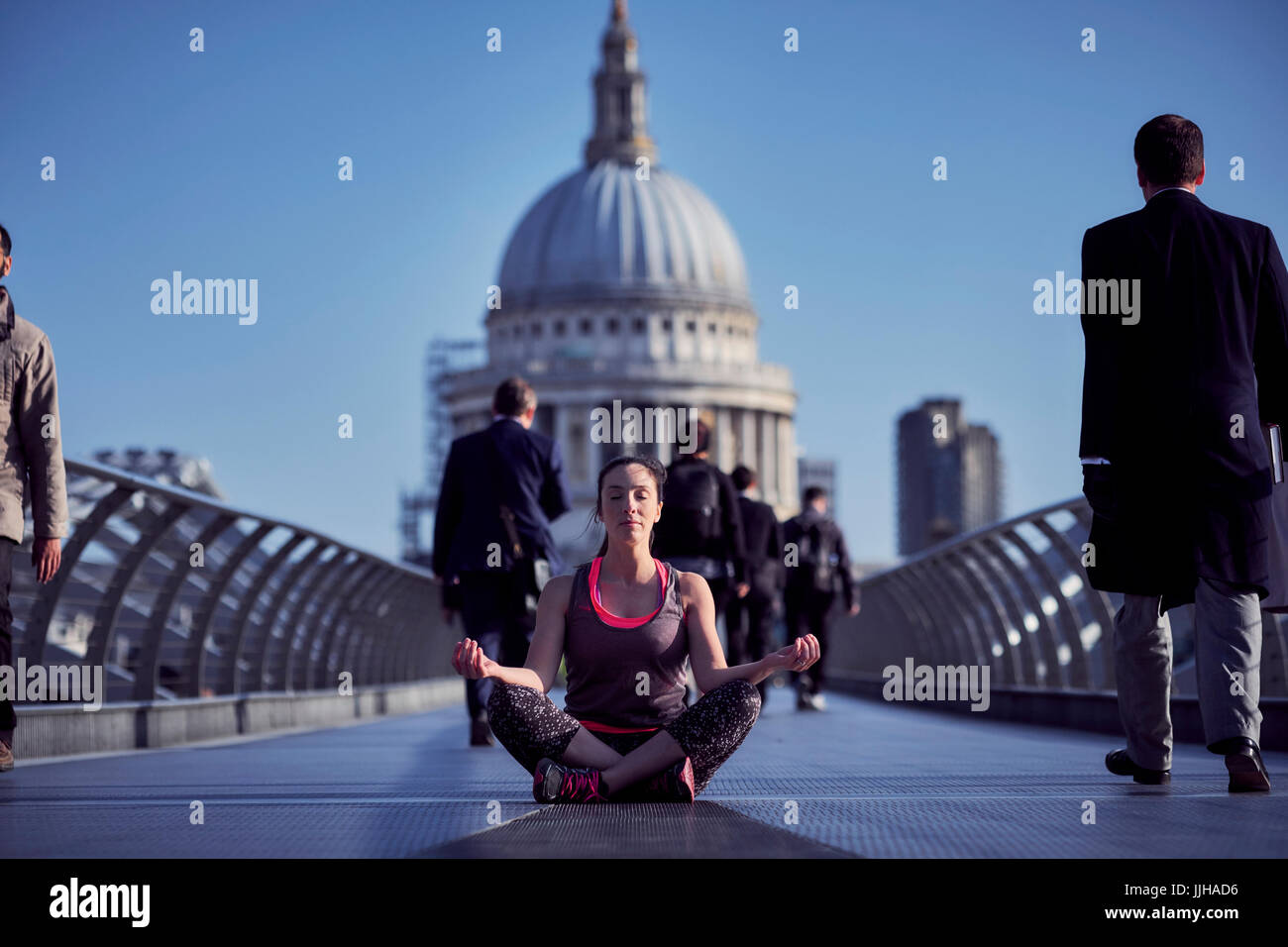 Eine Frau, die Meditation über die Millennium Bridge mit St. Pauls Kathedrale im Hintergrund. Stockfoto