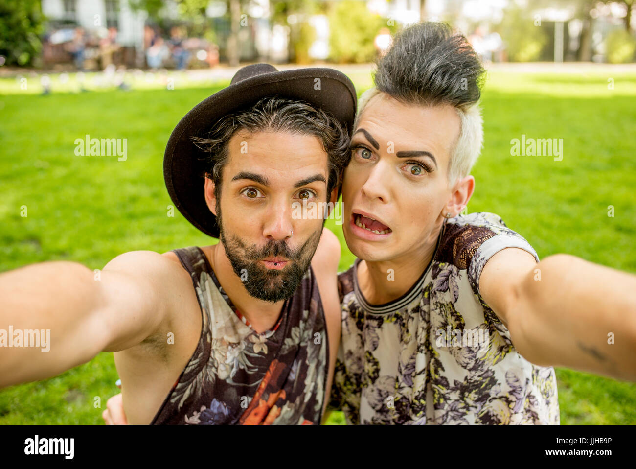 Ein schwules Paar unter Selfies in einem Park in London. Stockfoto