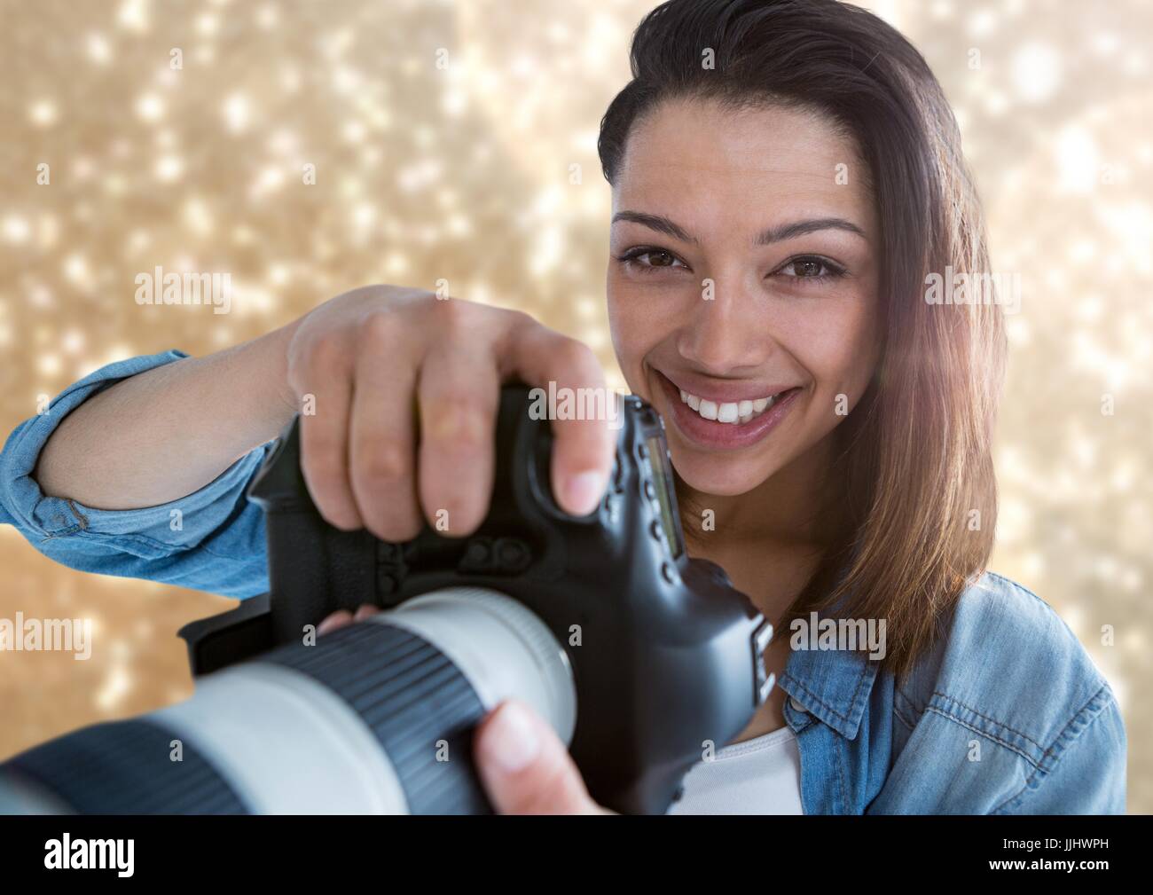 Fotografen, die lächelnd Vordergrund mit gold Lichter hinter Stockfoto