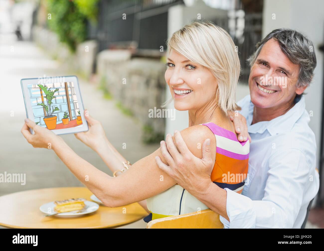 Glückliches Paar zeigt den 3D Entwurf des Büros mit Tablet-PC. (Farbe: blau, grün und Orange) Stockfoto