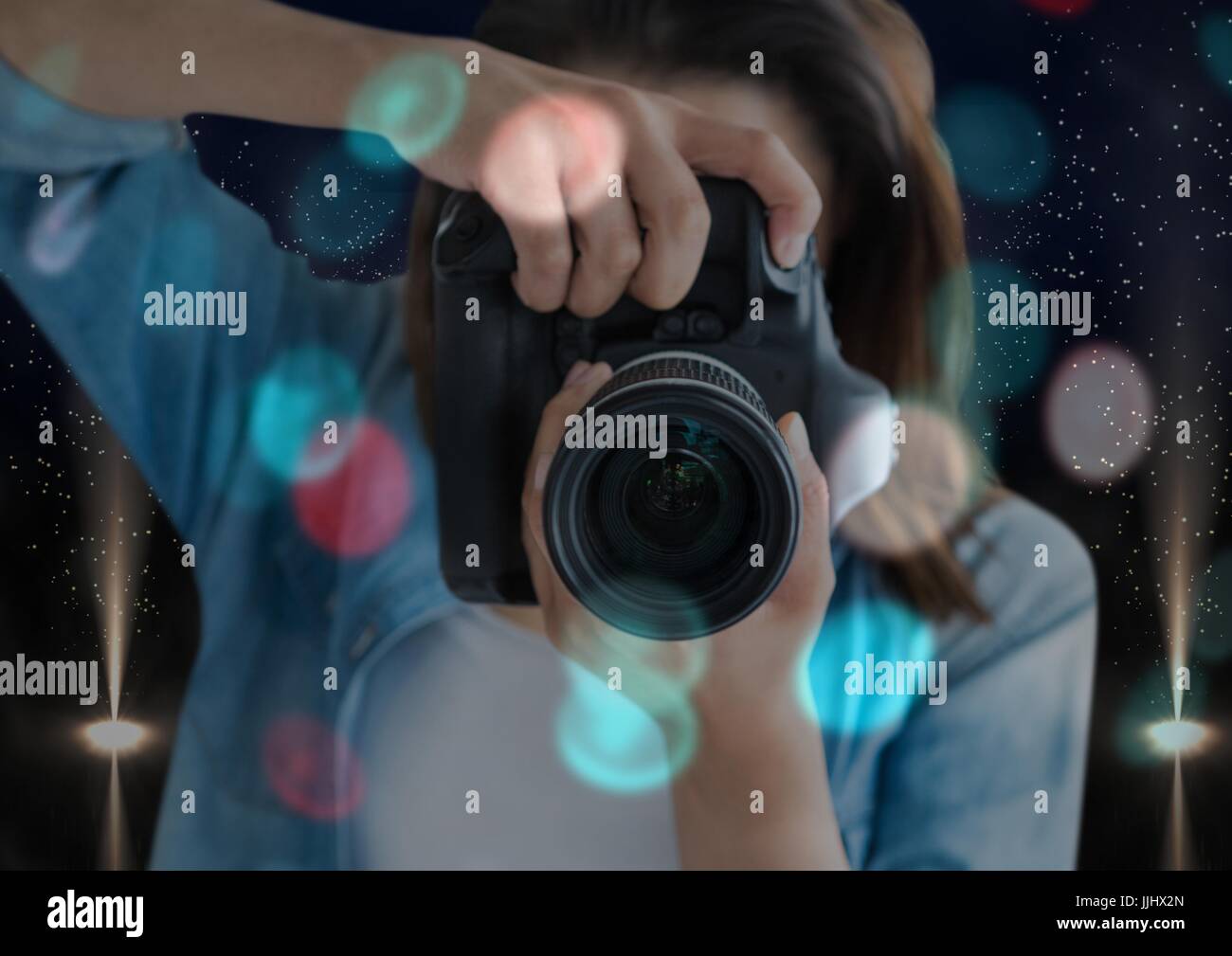 Fotograf Vordergrund fotografieren mit Spiegelreflex-Kamera. Blaue und rote Lichter Überlappung verschwommen und Stockfoto