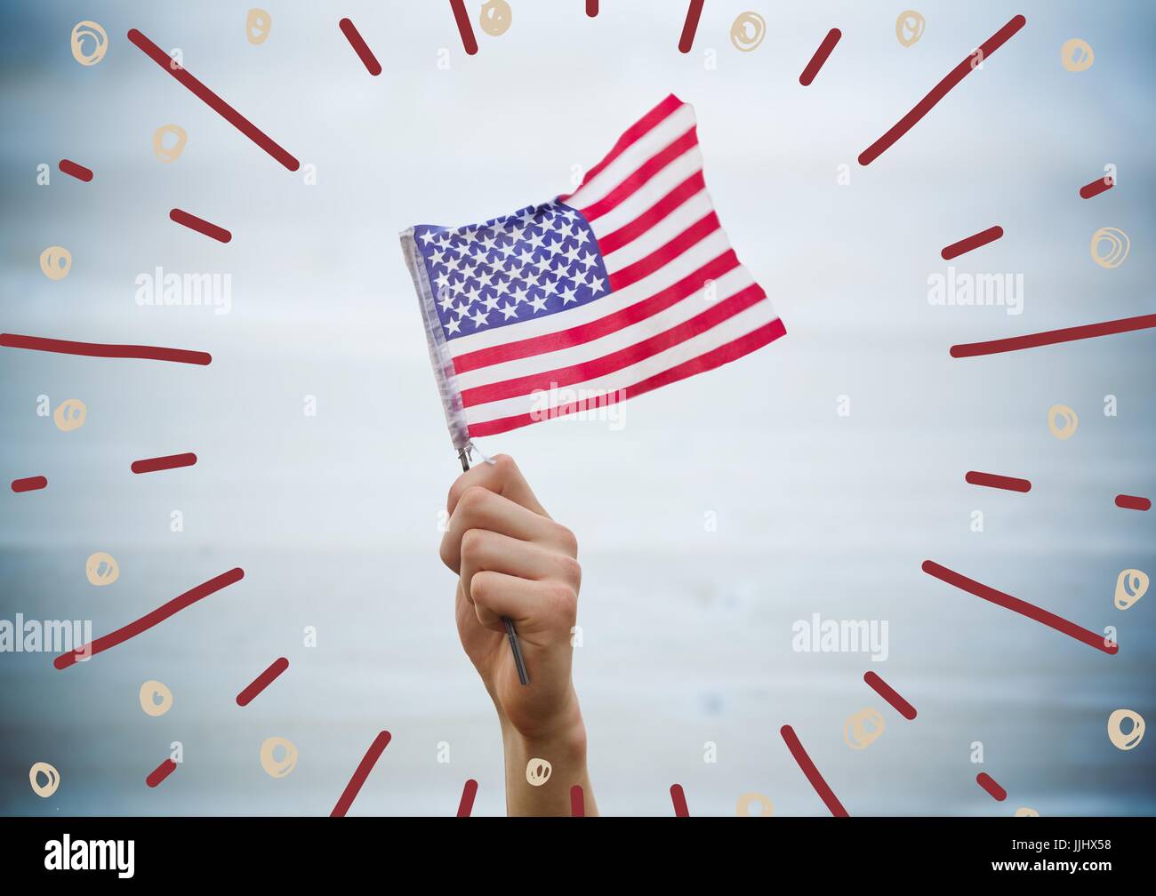 Hand, die amerikanische Flagge gegen verschwommene blaue Holzplatte mit Feuerwerk doodles Stockfoto