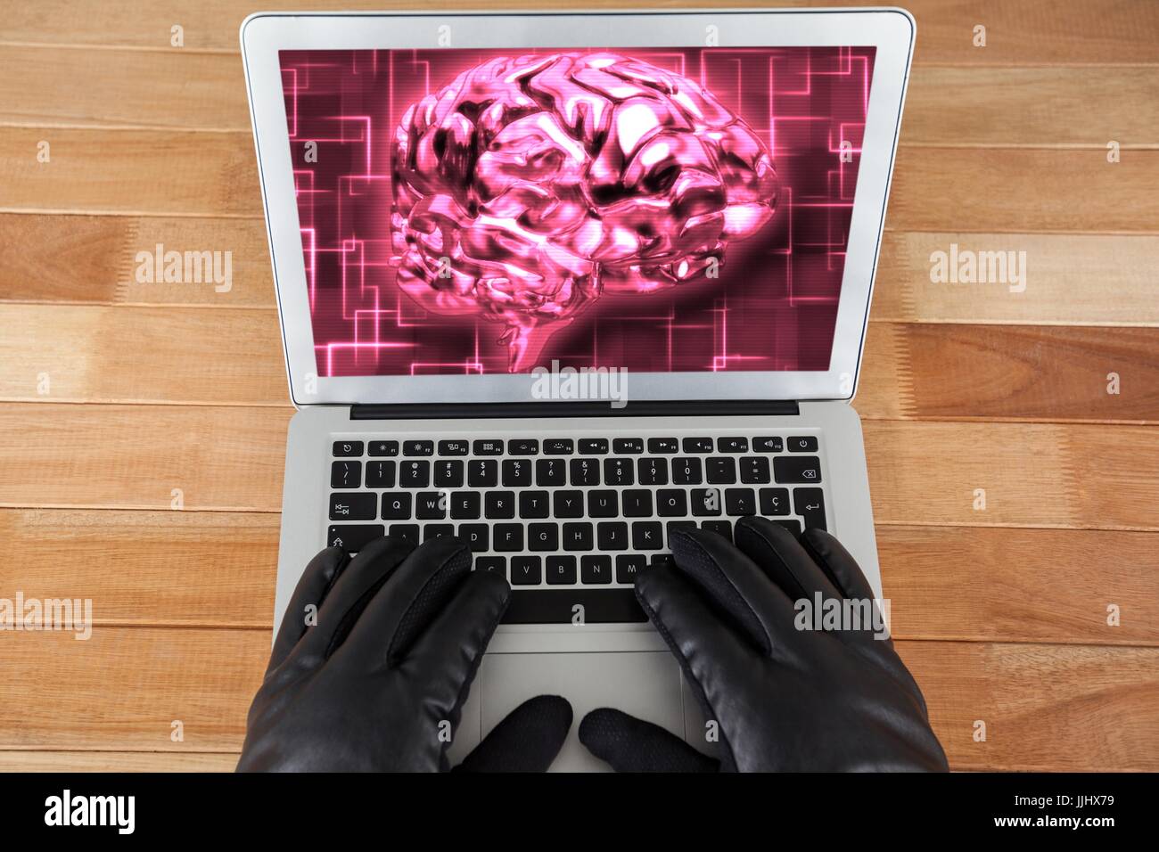Hacker mit Handschuhen mit einem Laptop mit einem rosa Gehirn auf desktop-Hintergrund Stockfoto