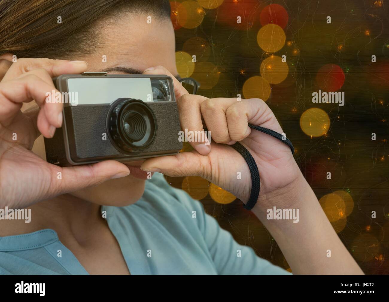 Fotografen nehmen Foto mit Vintage-Kamera (im Vordergrund). Verwischt Farbenlichter hinter Stockfoto