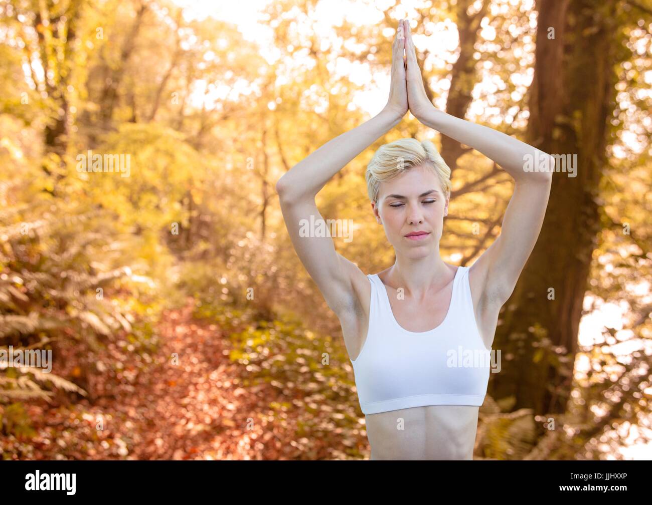 Frau gegen verschwommen Wald Meditation Stockfoto