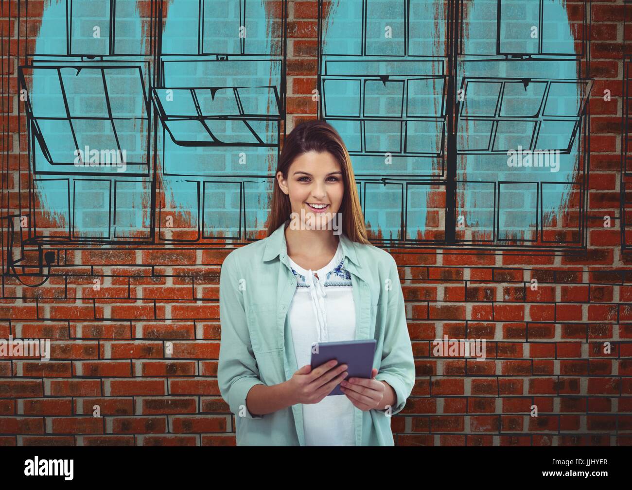 junge Geschäftsfrau lächelnd mit Tablet vor eine Mauer mit der Blaupause des Neubaus an der Stockfoto