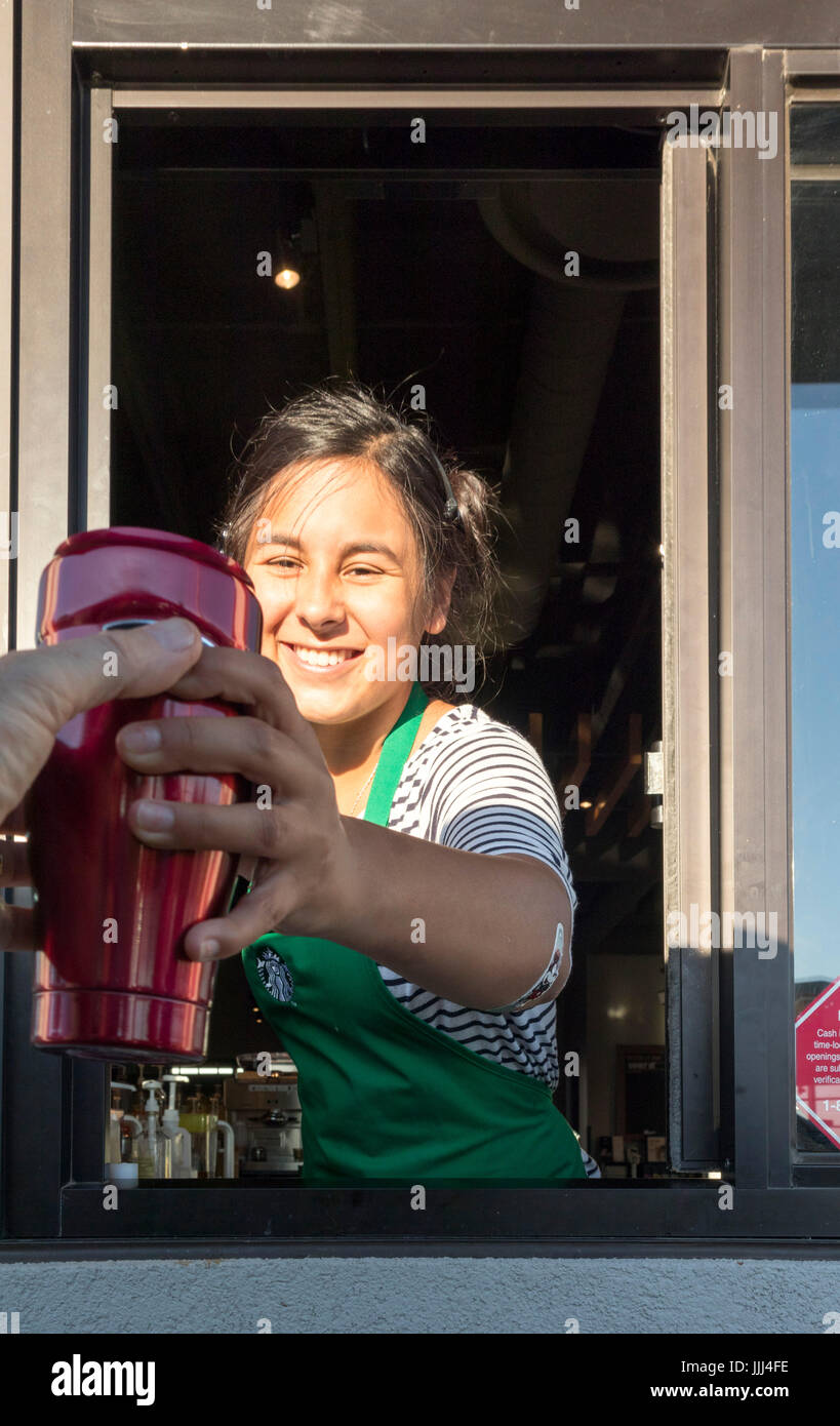 Server bei Starbucks Drive Thru Fenster nehmen oder empfangen von Kaffeebecher Stockfoto