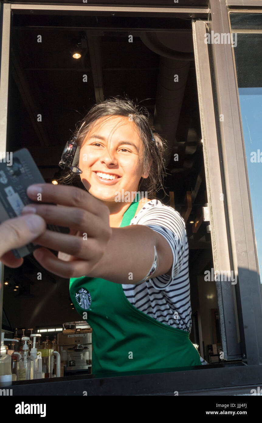 Server bei Starbucks Drive Thru Fenster nehmen oder Erhalt der Zahlung mit Kreditkarte Stockfoto