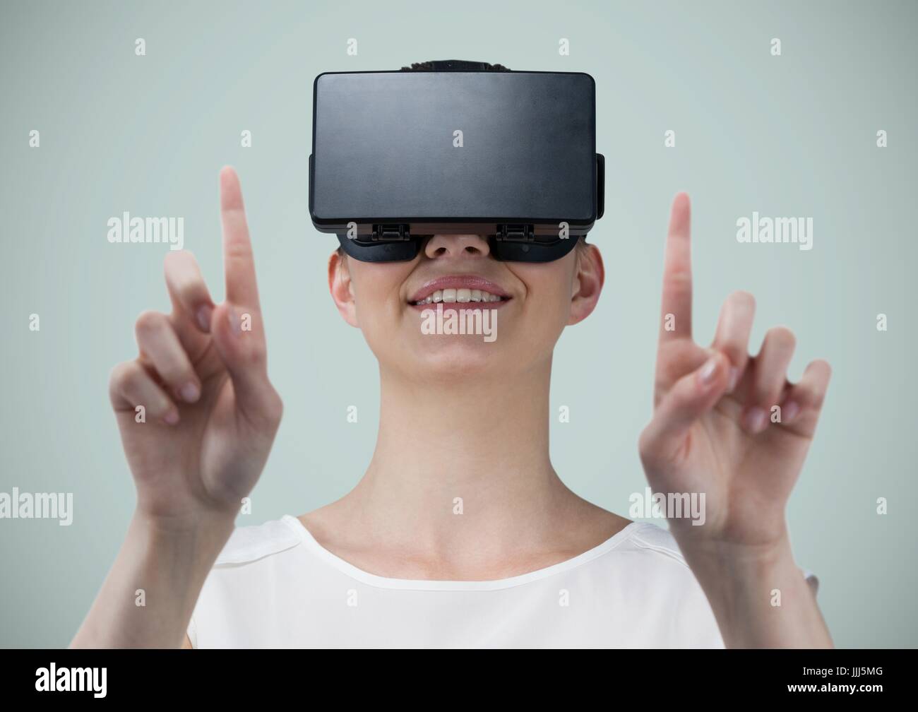 Frau in virtual-Reality-Kopfhörer vor hellen grauen Hintergrund Stockfoto