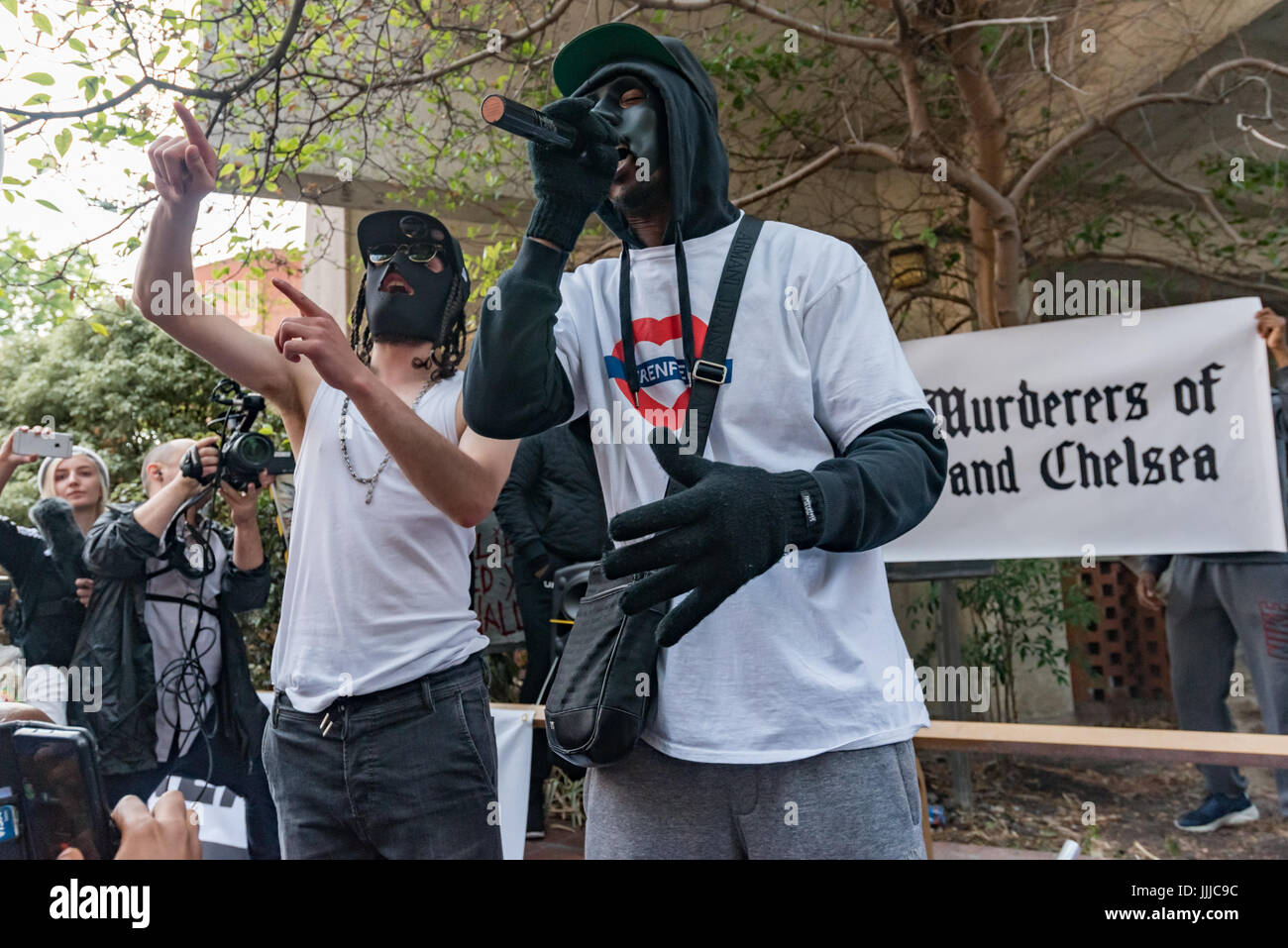 London, UK. 19. Juli 2017. London, UK. 19. Juli 2017. Lokale Gruppe "The Royal Mörder von Kensington und Chelsea" führen Sie ihr Lied über das Feuer auf den Protest von Grenfell Turm Überlebenden und Unterstützer bei der Ratsversammlung in Kensington Town Hall Ratsherren t fordert Rücktritt. Ein paar hundert Demonstranten besuchte der Rat treffen, obwohl einige Überlebende draußen gehalten wurden, bis der Bewohner Vertreter weigerte zu sprechen, bis sie in durften und gab es viele leere Plätze, während Hunderte mehr beobachtet die Verfahren auf einer Großleinwand außerhalb, mit Wut ausbrechen der Stockfoto