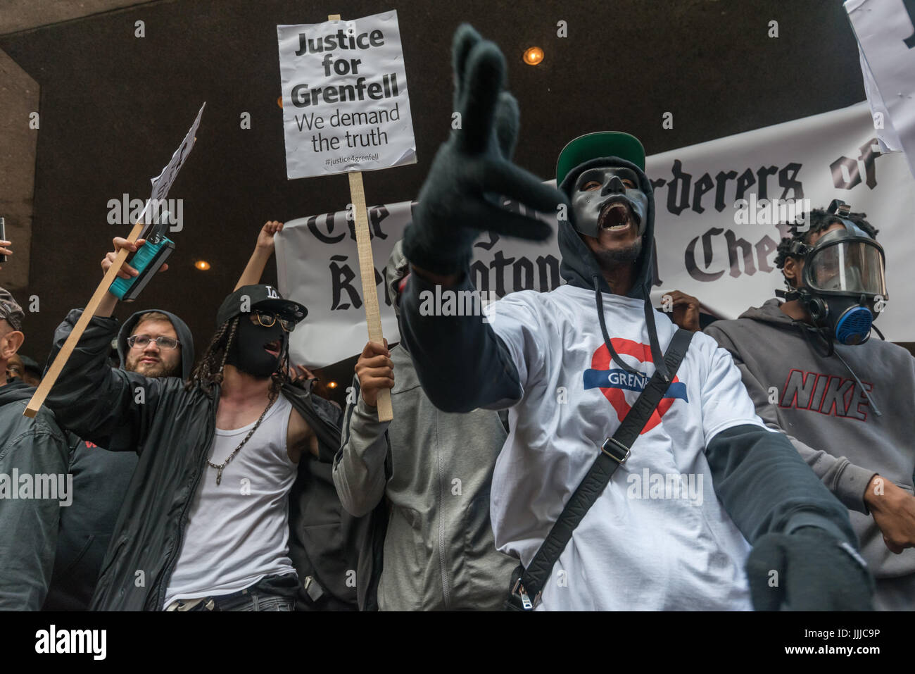 19. Juli 2017 - London, UK - London, UK. 19. Juli 2017. Mitglieder der lokalen Gruppe "The Royal Mörder von Kensington und Chelsea" kommen, um auf den Protest von Grenfell Turm Überlebenden und Unterstützer bei der Ratsversammlung in Kensington Town Hall Ratsherren "Rücktritt jetzt!" der Firma Botschaft überbringen durchführen. Ein paar hundert Demonstranten besucht, obwohl einige Überlebende draußen gehalten wurden, bis der Bewohner Vertreter weigerte zu sprechen, bis sie in durften und es viele leere Plätze, gab während Hunderte mehr die Verfahren auf einer Großleinwand außerhalb, sahen Erupti Tagung des Rates Stockfoto