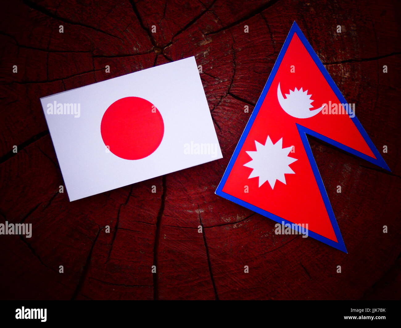 Japanische Flagge mit Nepali Flagge auf einem Baumstumpf, isoliert Stockfoto