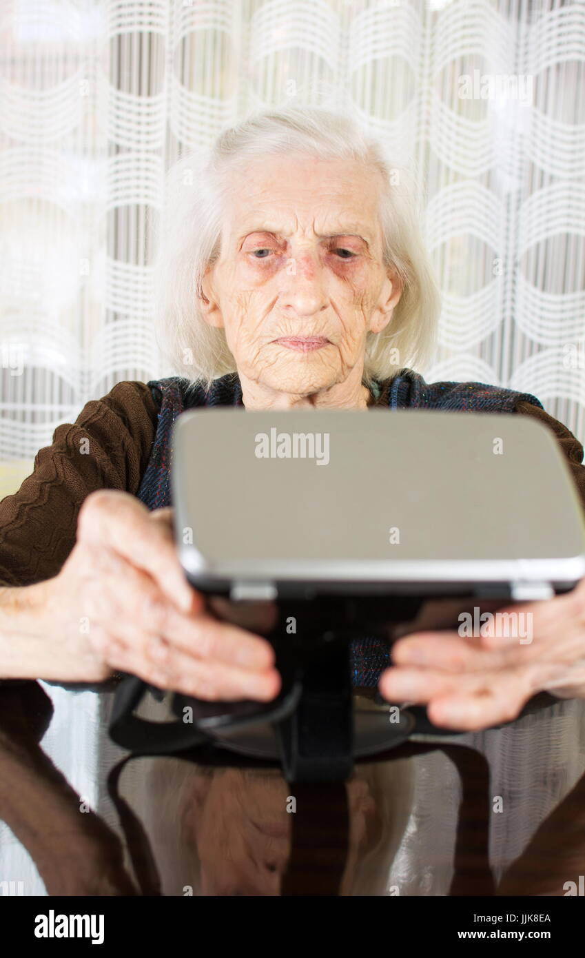 Ältere Frau mit virtual-Reality Brille zu Hause Stockfoto