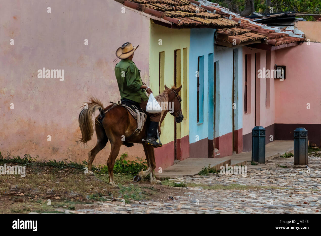 Pferde und Cowboys sind einem gemeinsamen Standort auf die gepflasterten Straßen von TRINIDAD, Kuba Stockfoto