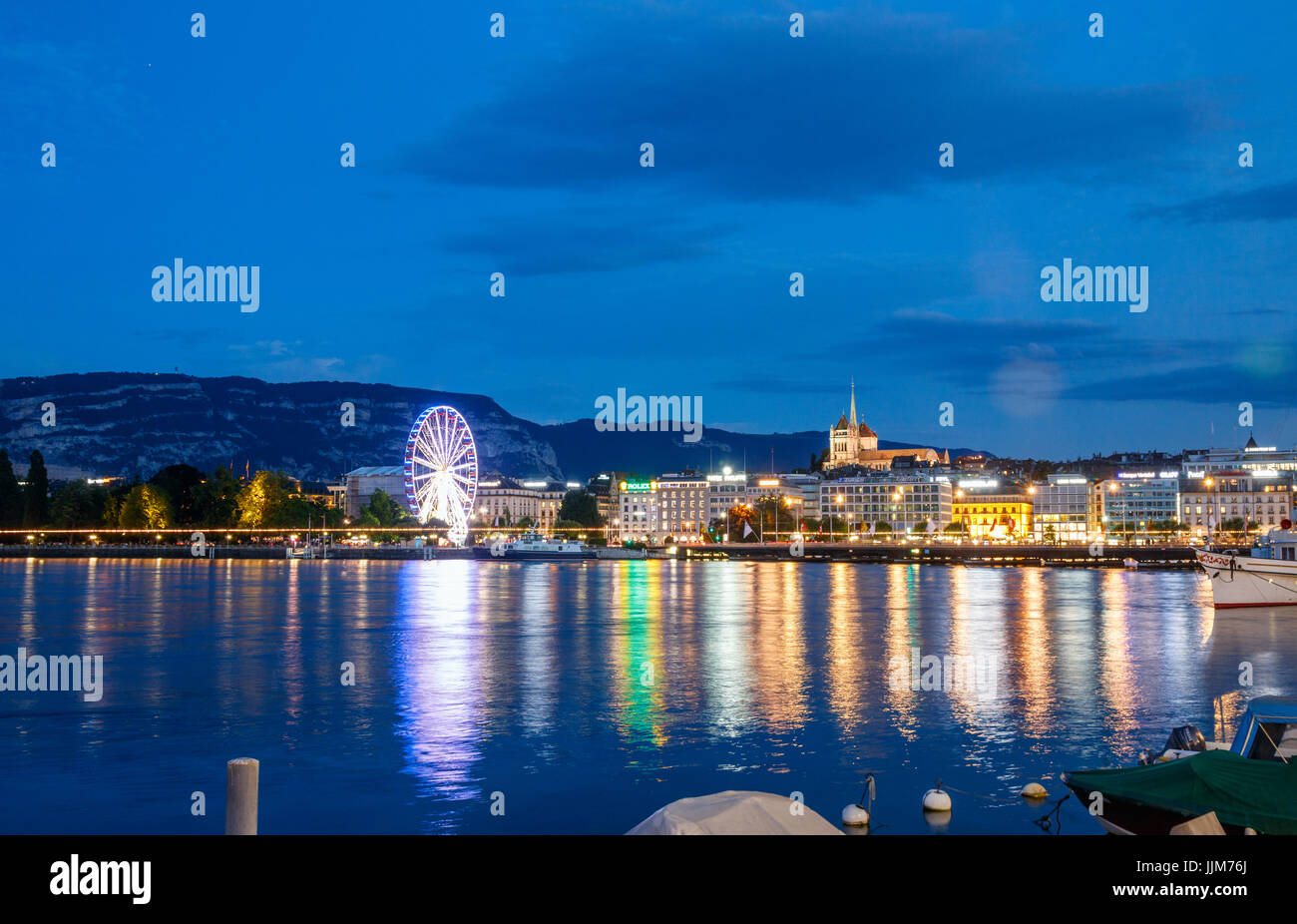 Blick auf die Rhone und die Altstadt mit dem St.-Petri Dom und ein Riesenrad am Ufer. Genf, Schweiz. Stockfoto