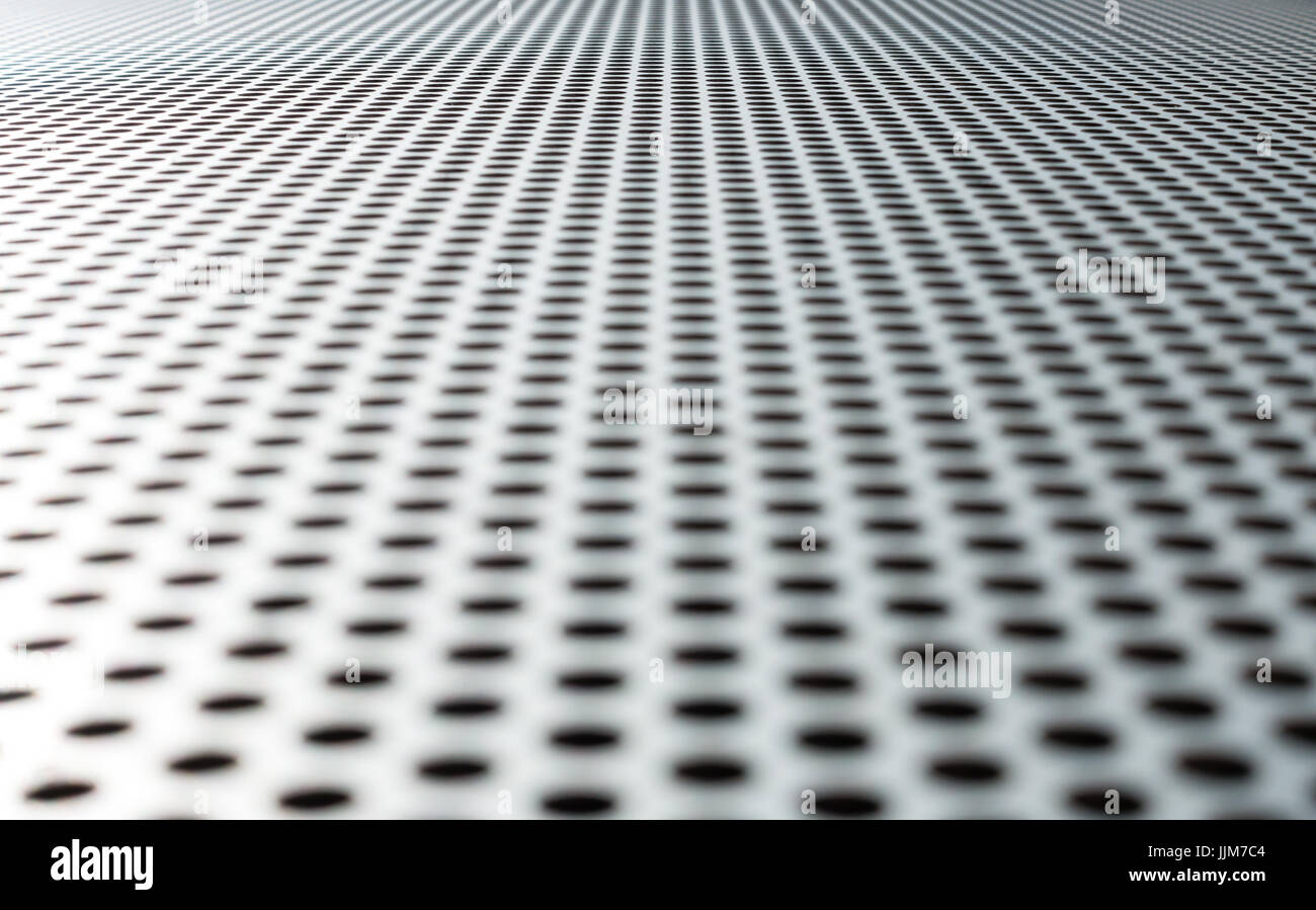 Grau Metall Hintergrund, runde perforiertes Metall Textur. Reflexionen und verwischen. Stockfoto