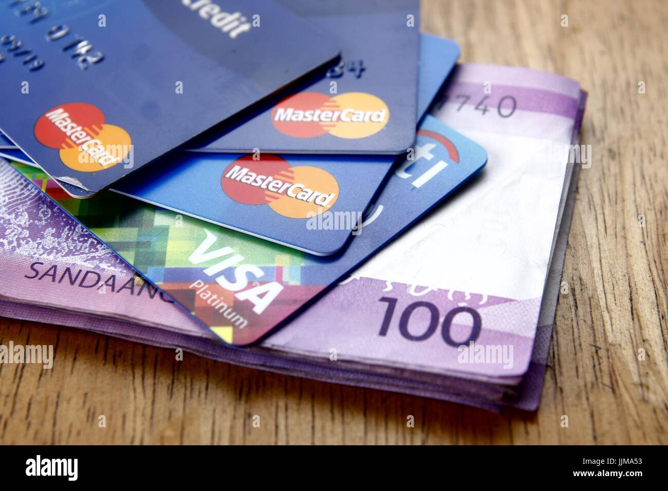 ANTIPOLO CITY, Philippinen - 17. Juli 2017: Ein Bündel von Mastercard und Visa Kreditkarten und hundert Philippine Peso-Scheine auf den Tisch. Stockfoto