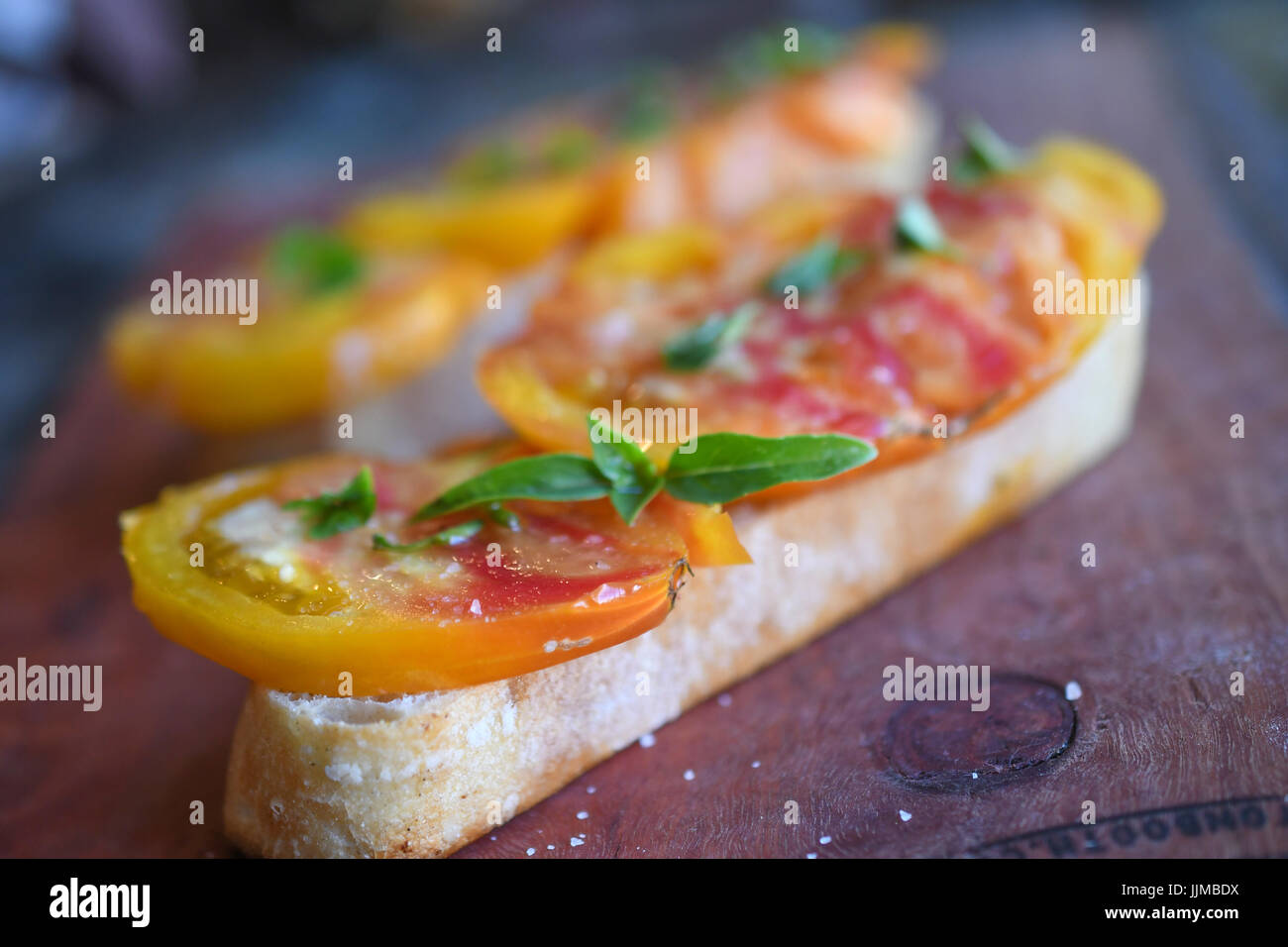 Erbstück-Tomaten-Bruschetta mit Basilikum sprintete an der Spitze Stockfoto