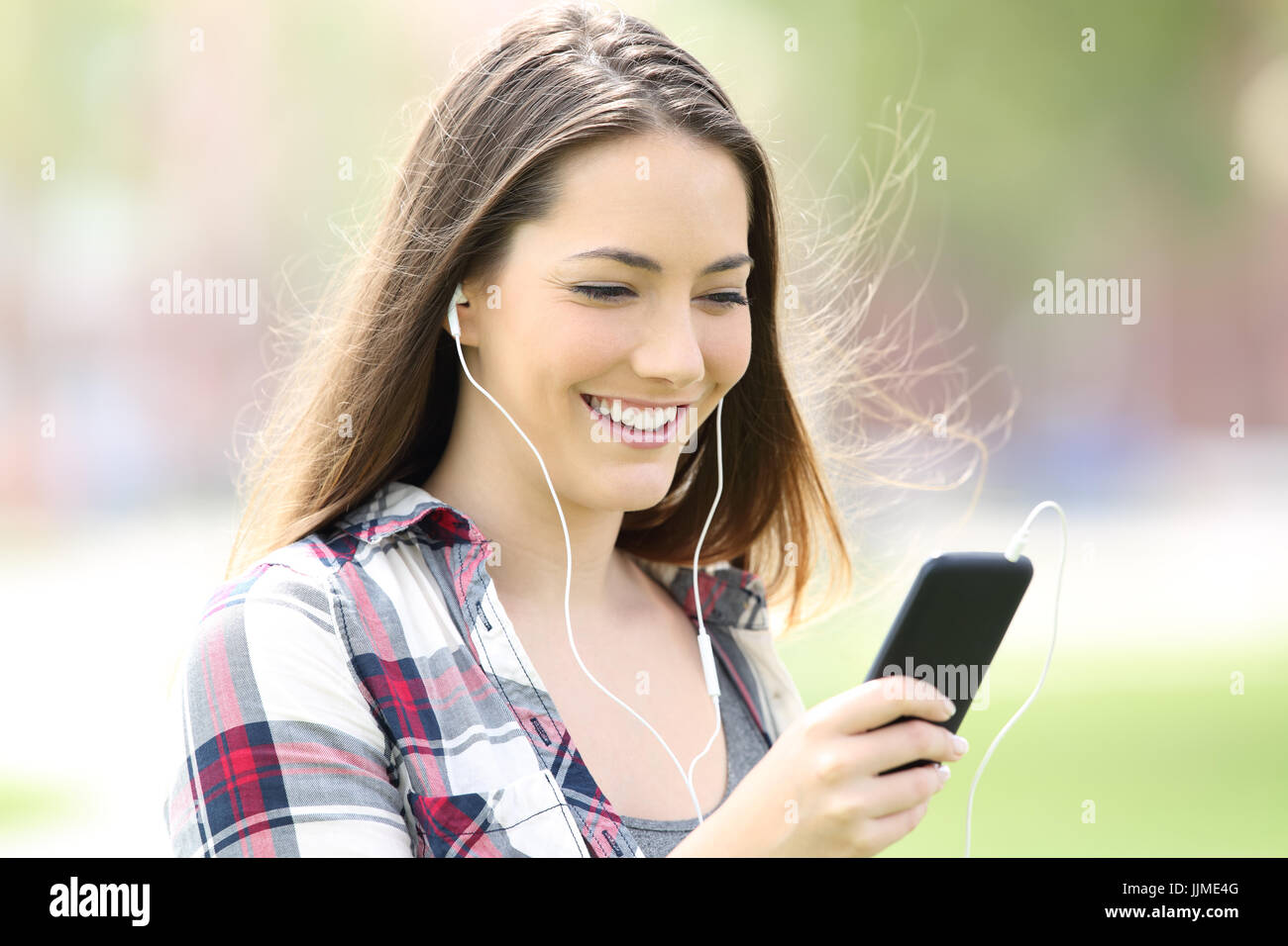 Jugendlich Mädchen Musik hören mit Ohrhörern und zu Fuß auf der Straße Stockfoto