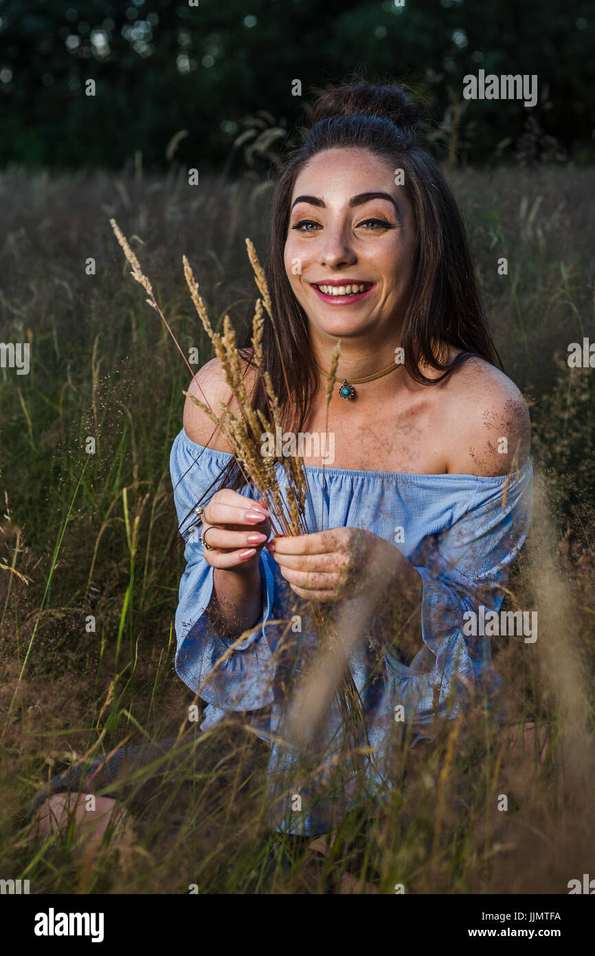 Mein Freund kichert während lange Strängen Gras auf einer Wiese in der Nähe von Liverpool zu pflücken. Stockfoto