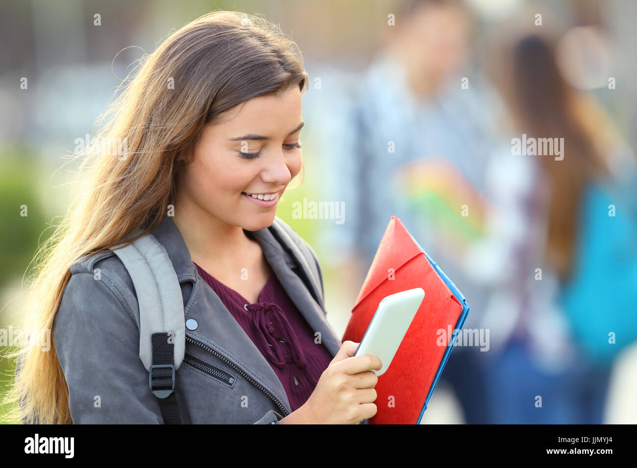 Einzelne student prüfen smart phone und zu Fuß auf der Straße Stockfoto