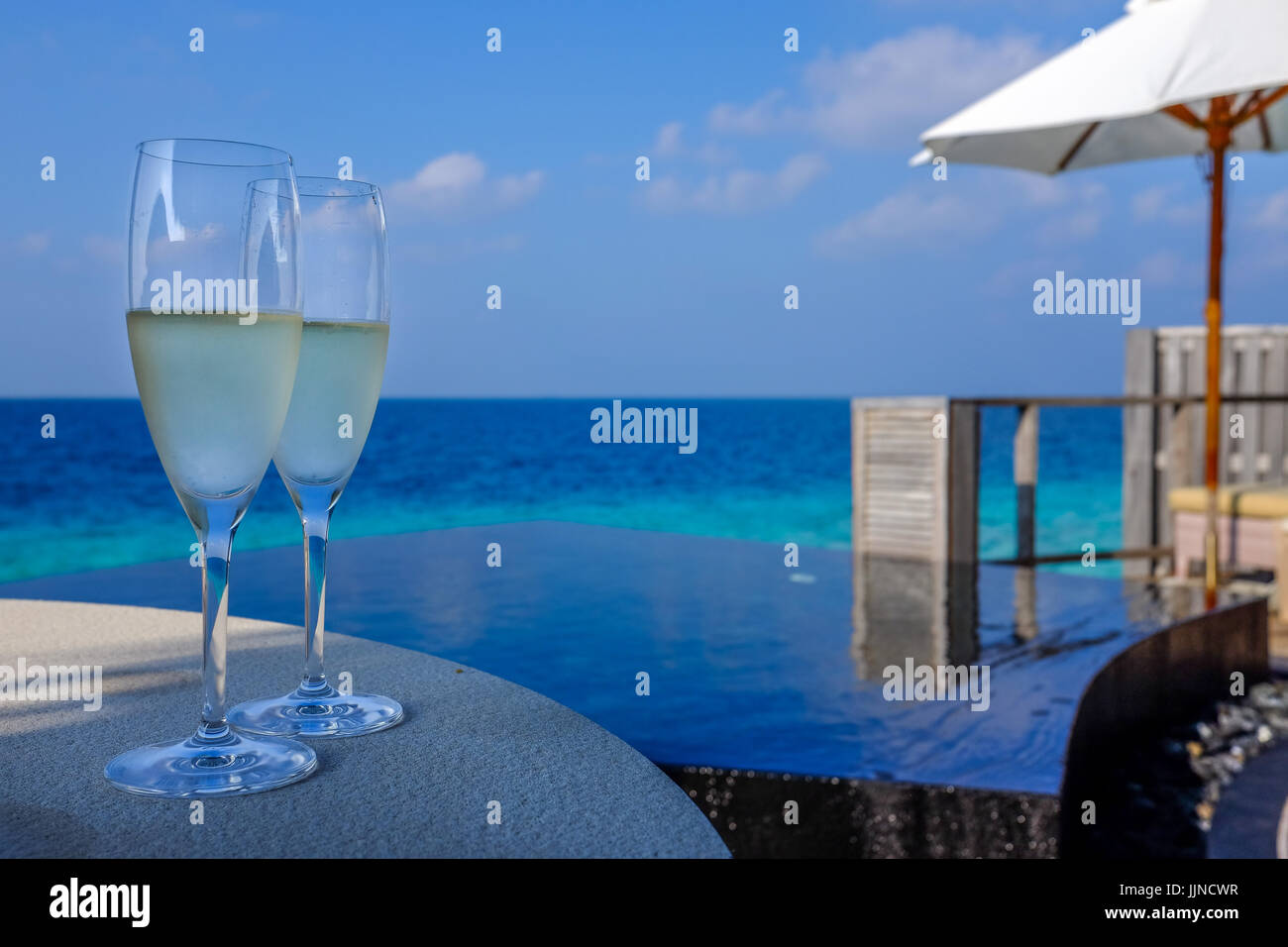 Ein paar Sektgläser sind Pool-Seite für ein paar auf ihrer eigenen Terrasse in einem Luxus-Resort auf den Malediven genießen festgelegt. Stockfoto