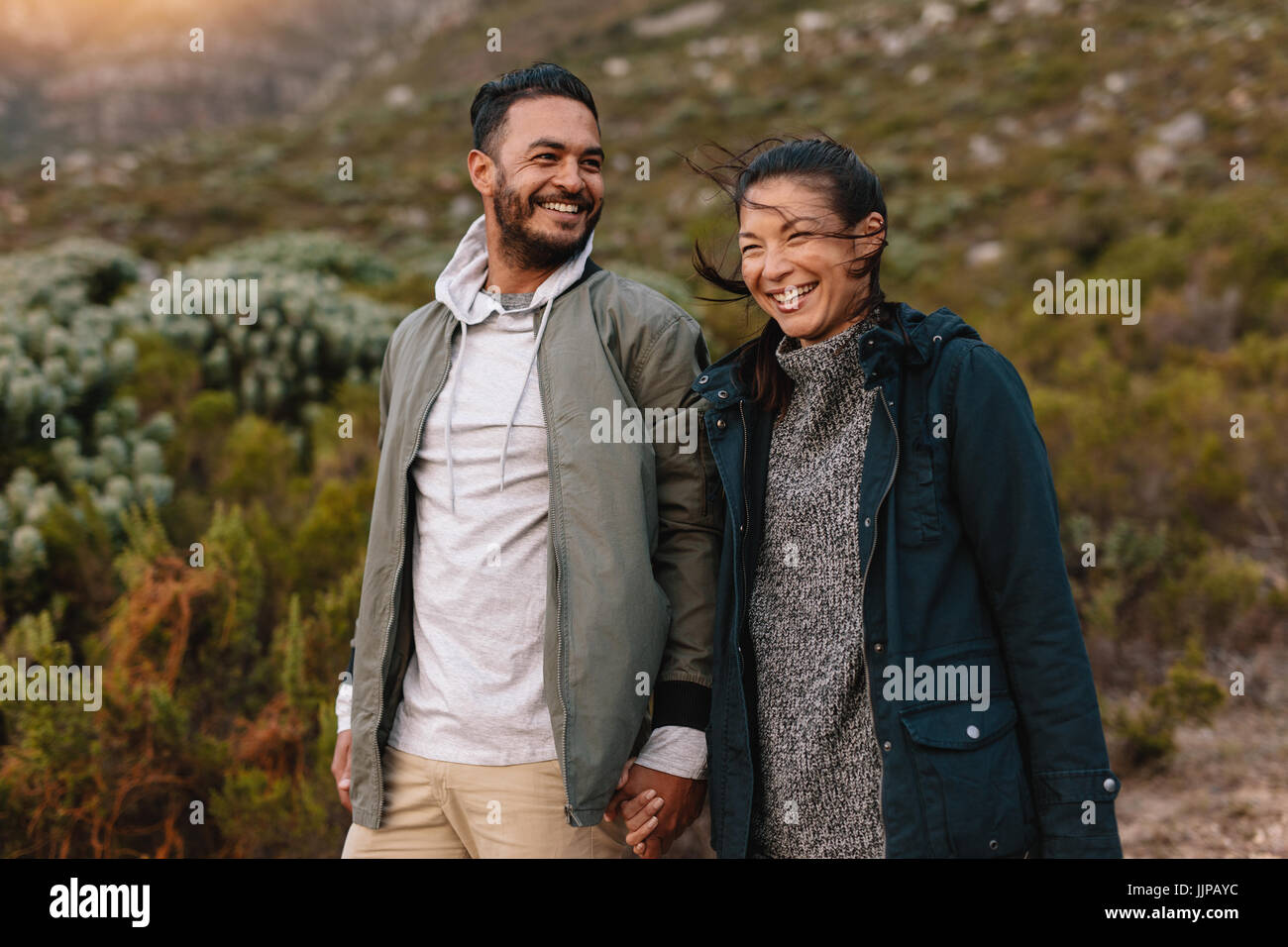 Porträt von lächelnden jungen Paare, die auf dem Lande. Junger Mann und Frau in der Natur wandern. Stockfoto