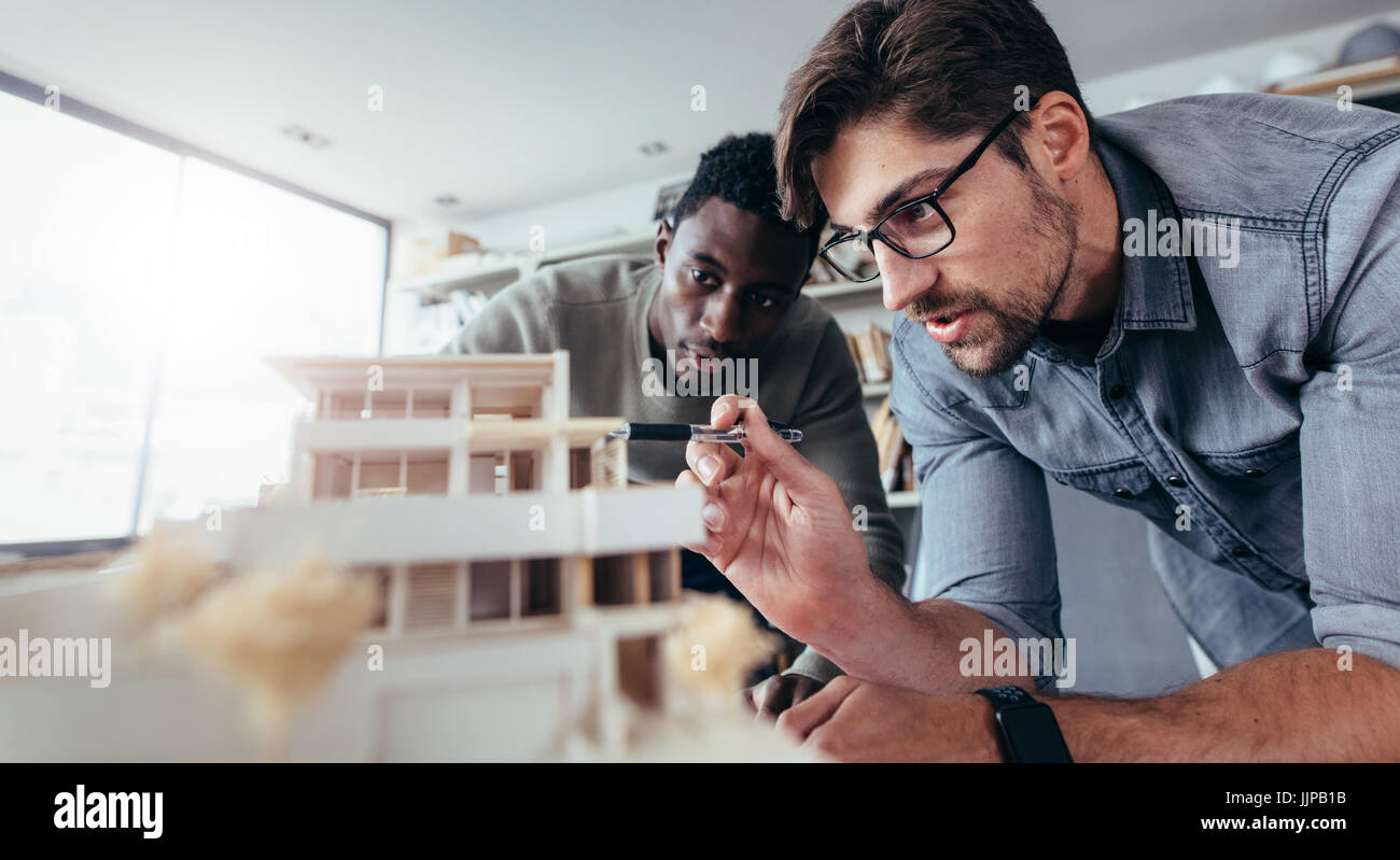 Zwei männliche Architekten Büro über Hausmodell zu diskutieren. Architekten arbeiten auf ein Architekturmodell. Stockfoto