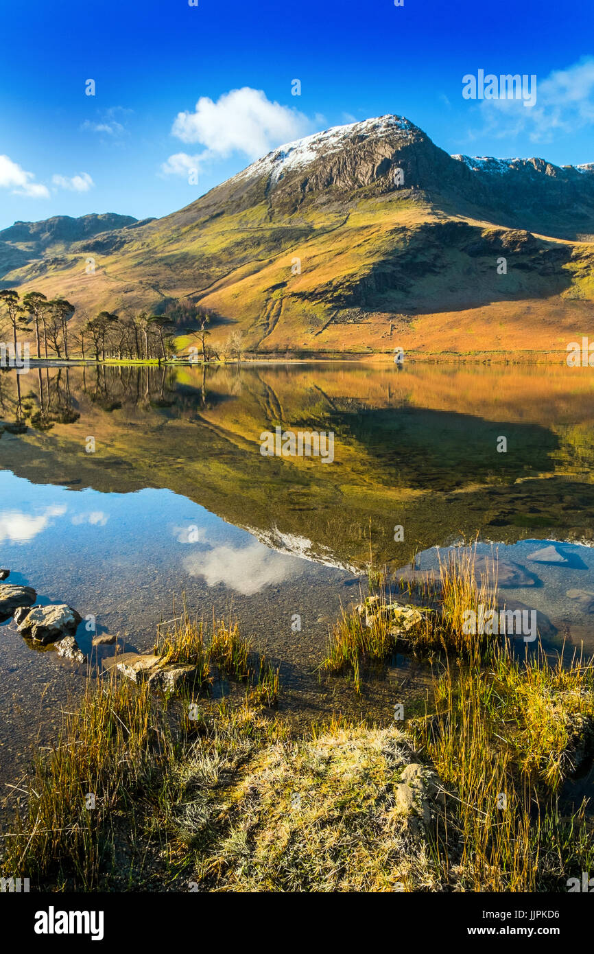 Hohe Felsen spiegelt sich in Buttermere an einem ruhigen Wintermorgen in den Lake District National Park Stockfoto