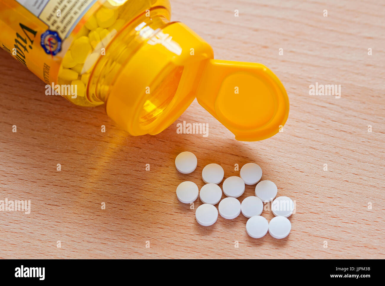 Vitamin D-Tabletten aus Plastikflasche verschütten. Stockfoto