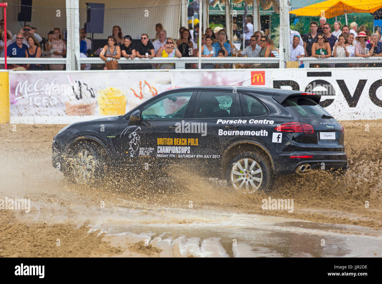 Charity-Rennen zwischen einem Porsche Wagen und Pferd findet statt am Strand bei den British Beach Polo Championships auf Sandbänken Strand, Poole Dorset im Juli Stockfoto