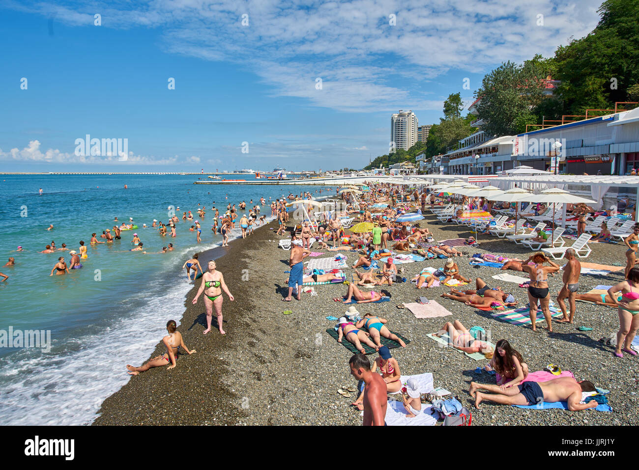 Sochi, Russland - 06. Juli 2017. die Leute Schwimmen und Sonnenbaden am Strand der Stadt Sotschi. Strand mit Touristen, Sonnenliegen und Sonnenschirmen Stockfoto