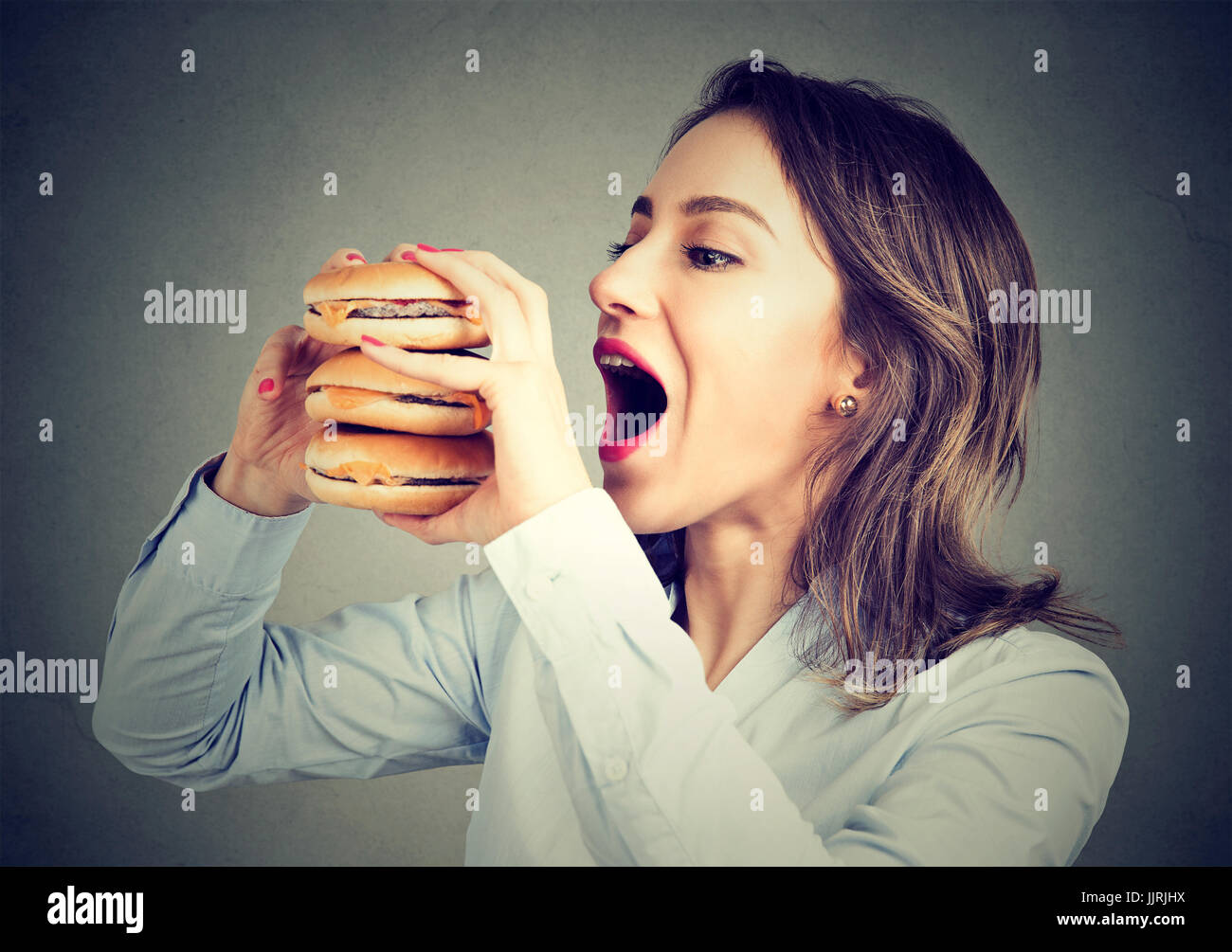 Frau, die Lust auf eines leckeren doppelten-Burger zu essen Stockfoto