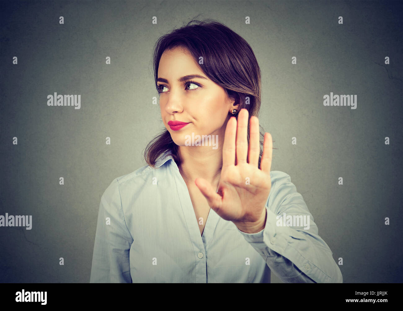 Böse Frau geben sprechen zur hand Geste mit der Handfläche nach außen isolierten graue Wand Hintergrund. Negative menschliche Emotionen Körpersprache Stockfoto