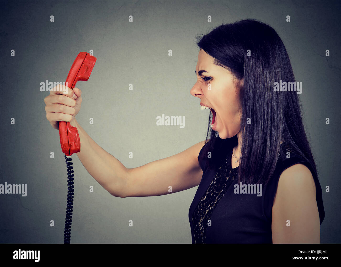 Böse Mädchen schreien am Telefon Stockfoto